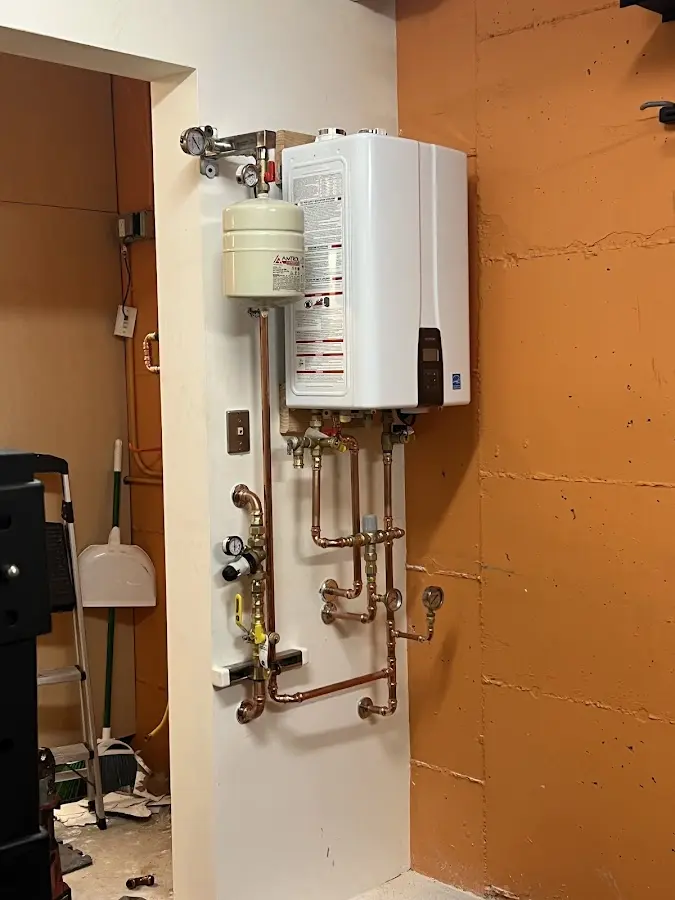 Plumbing technician inspecting water heater connections in Conshohocken